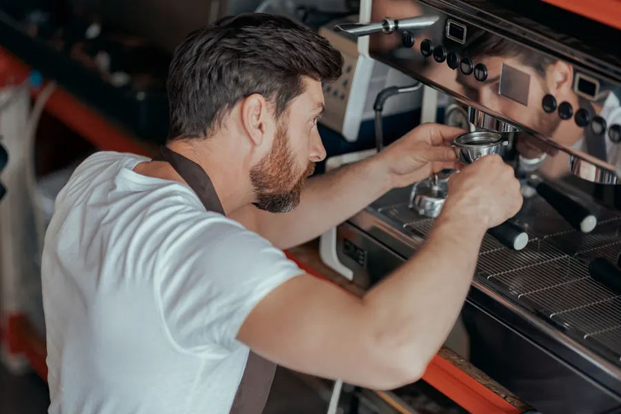 Τεχνικός συντηρεί μηχανή espresso